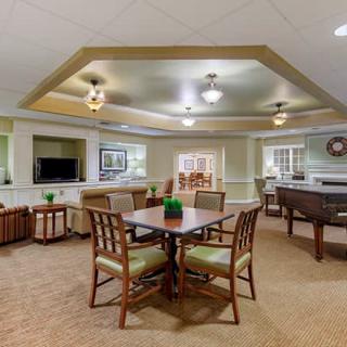 A cozy and well-furnished living area featuring a dining table, comfortable seating, and a television.