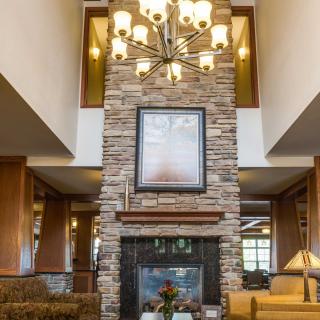A cozy living room interior featuring a stone fireplace and an elegant chandelier.
