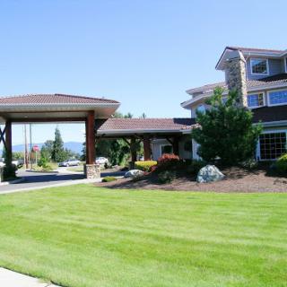 A modern residential building with a manicured lawn and landscaped surroundings.