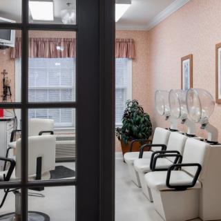 A glimpse into a cozy hair salon waiting area with chairs and hair dryers.