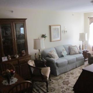 A cozy living room with a sofa, wooden furniture, and soft lighting.