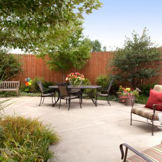 A cozy outdoor patio with comfortable seating and lush garden surroundings.