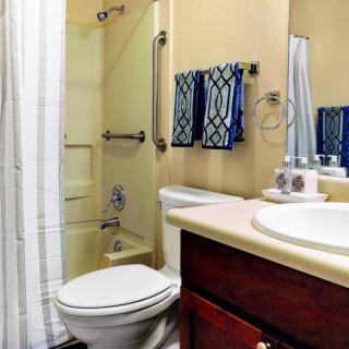 A small bathroom with a shower, toilet, and sink.
