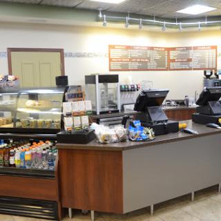 A cozy cafe counter displaying a variety of baked goods and beverages.