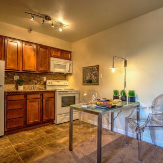 A cozy kitchen with wooden cabinets, modern appliances, and a small dining area.