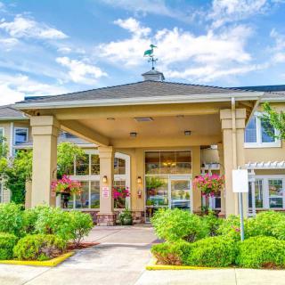 A welcoming entrance of a modern building with well-maintained landscaping.