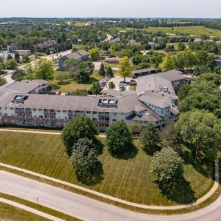 An aerial view of a suburban area featuring a large building surrounded by roads and trees.