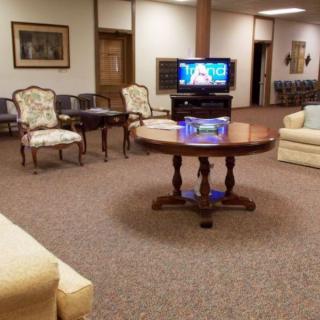 A cozy waiting room with various seating options and a television.