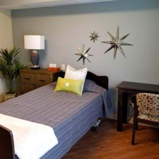 A cozy bedroom with a single bed, decorative wall art, and modern furnishings.