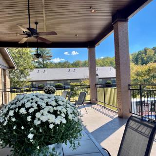 A sunny day on a cozy patio with flowers, seating, and a scenic view.
