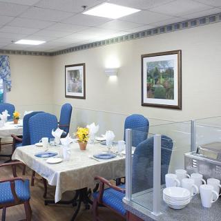 A well-decorated dining area with tables set for a meal, featuring blue chairs and wall art.