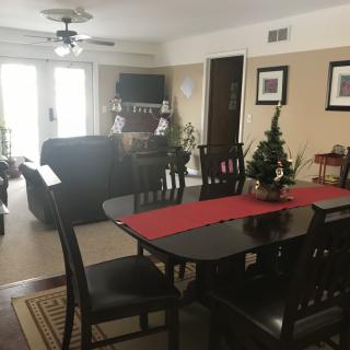 A cozy dining and living room area with dark wood furniture and holiday decorations.