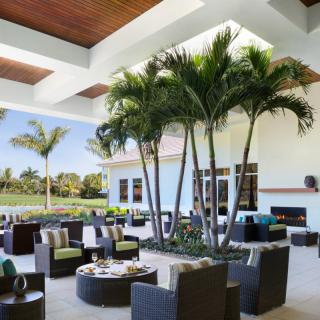A modern outdoor patio featuring comfortable seating and palm trees, ideal for relaxation.