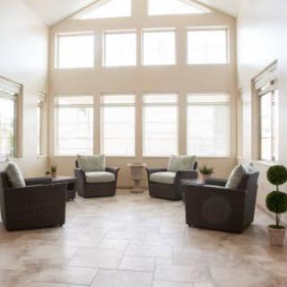 A bright, modern sunroom with large windows and comfortable seating.