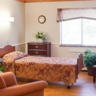 A cozy bedroom with a single bed and natural light streaming through the window.