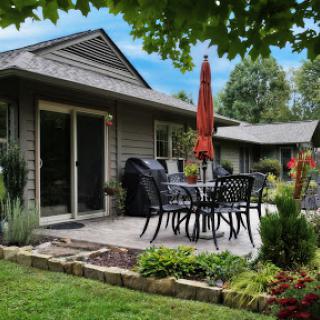 A cozy outdoor patio area perfect for relaxation, featuring stylish furniture and lush greenery.