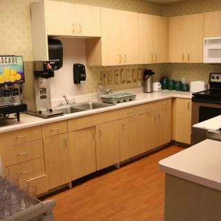 A modern kitchen with wooden cabinets and appliances such as a microwave and coffee maker.