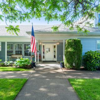 A charming house with a well-maintained front yard and an American flag displayed by the entrance.
