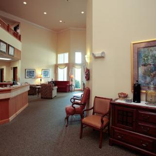 A spacious lobby featuring a reception area with comfortable seating and decorative artwork.