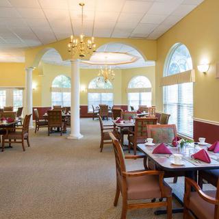 An elegant dining room with neatly arranged tables and large windows.