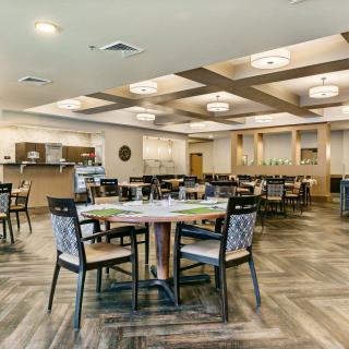 A modern and spacious restaurant dining area with elegant furnishings and lighting.