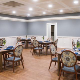 A well-lit dining room with elegantly arranged tables and chairs.