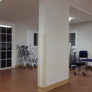 A hospital corridor with wheelchairs lined against the wall.