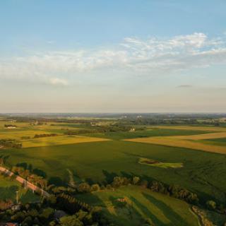 A picturesque view of expansive fields under a clear sky, showcasing the beauty of rural landscapes.