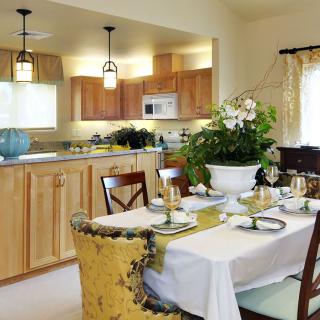 A cozy open-concept kitchen and dining area with a beautifully set table and wooden cabinets.