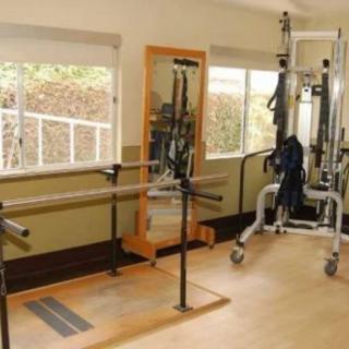 A well-equipped indoor gym with exercise machines and a large mirror.