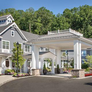 A large residential house with a grand entrance and lush surroundings.