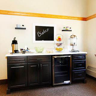 A stylish kitchen break area featuring a coffee station and modern appliances.