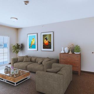 A cozy living room with a large sofa, coffee table, and decorative artwork on the walls.