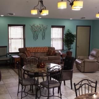 A cozy living room featuring a sofa set, tables, chairs, and decorative lighting.