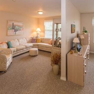 A cozy living room with a large sectional sofa and warm lighting.