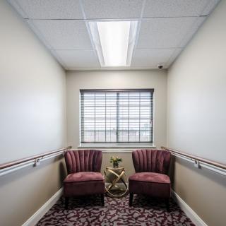 A small corridor with two chairs facing a window, featuring decorative accents.