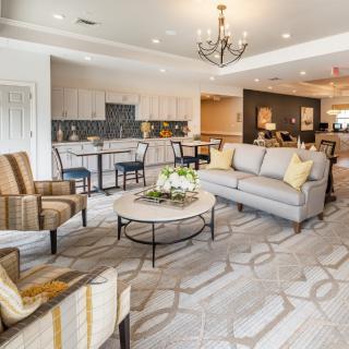 A spacious and elegantly designed living room with modern furniture and a chandelier.