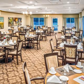 An elegant dining room set with tables and chairs, ready for guests.