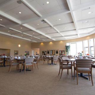A spacious dining area with modern furnishings and large windows.