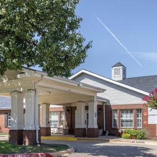 A view of the entrance to a residential building with well-maintained landscaping.