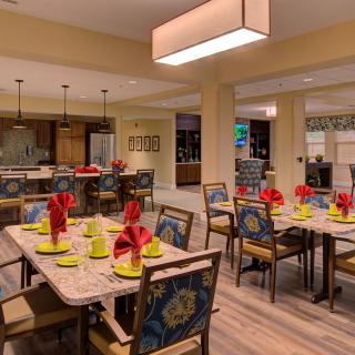 A beautifully arranged dining area with tables set for guests, featuring decorative elements and ambient lighting.