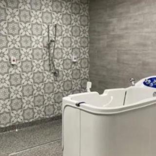 A modern bathroom with an accessible bathtub and decorative wall tiles.