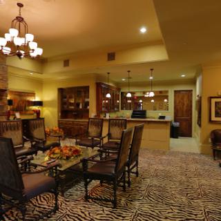 A cozy lounge area featuring comfortable seating, warm lighting, and a stylish zebra print carpet.