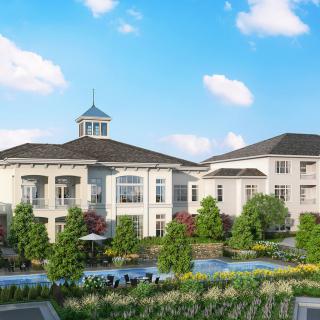 A beautiful residential building with a manicured garden and clear blue skies.