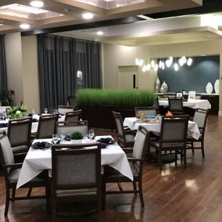 A well-lit restaurant dining area with elegantly arranged tables and chairs.