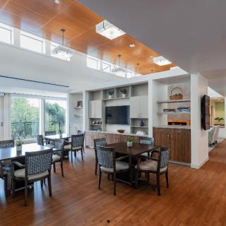 A modern dining area with wood flooring and ample natural light.