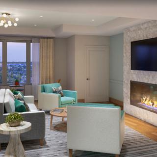 A modern living room featuring a cozy fireplace, stylish furniture, and large windows.