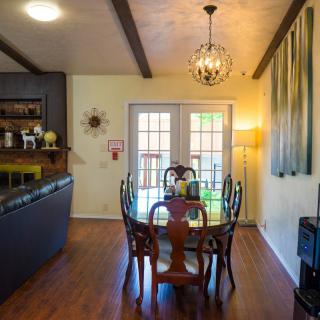 A cozy dining room with a wooden table and chairs, featuring warm lighting and elegant decor.