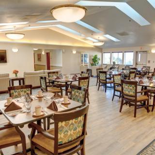 A well-lit dining room with neatly arranged tables and chairs, showcasing a cozy atmosphere.