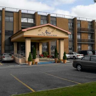 A hotel entrance with a parking area in front.
